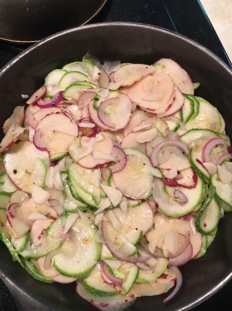 Sliced potatoes and zucchini in cast iron skillet