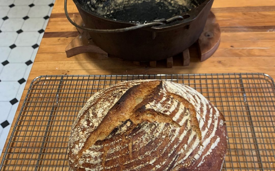 Cast iron Dutch oven and a round loaf of bread