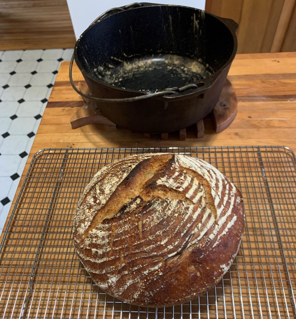 Cast iron Dutch oven and a round loaf of bread